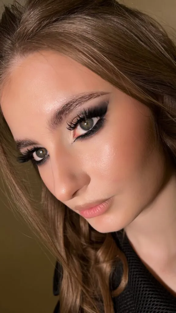 Dramatic black smokey eyes event makeup with nude lips and glowing skin in Chicago