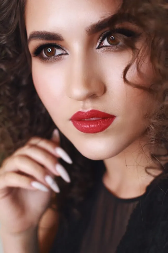 Red lips glam event makeup close-up with glowing skin and smokey eyes in Chicago