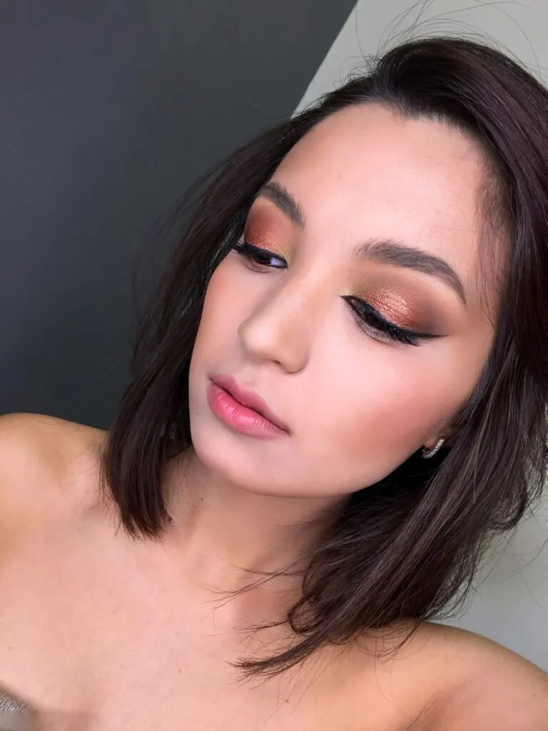Bronze glam event makeup with shimmer eyeshadow and nude lips in Chicago